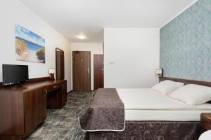 a hotel room with a bed and a flat screen tv at WILLA SKIPPER in Rewal