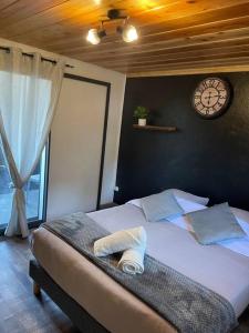 Un dormitorio con una cama con un reloj en la pared. en Bungalow la Jo Ya avec jacuzzi en supp À Bras-Sec, en Cilaos