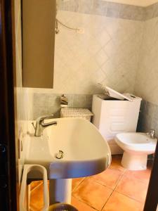 y baño con lavabo y aseo. en Le case di Bea, en Santa Teresa Gallura