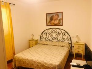 1 dormitorio con 1 cama y una foto en la pared en Le case di Bea en Santa Teresa Gallura