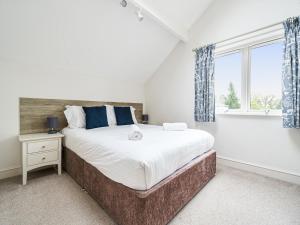 - une chambre avec un grand lit et une fenêtre dans l'établissement Hazel - Woodland Cottages, à Bowness-on-Windermere