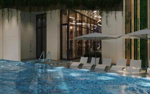 una piscina con sedie e ombrelloni in un edificio di Adamas Boutique Hotel Nha Trang a Nha Trang