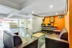 a waiting room with leather chairs and a table at UPAR Hotels near Bagmane Tech Park in Bangalore