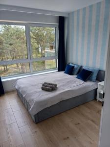 1 dormitorio con 1 cama grande con almohadas azules en Apartament przy plaży - Rowy, en Rowy