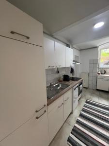 a kitchen with white cabinets and a sink at Berlin-Kreuzberg Madness in Berlin