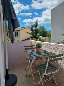 a table and chairs on a balcony with an umbrella at Chez Nous - Studio in La Môle