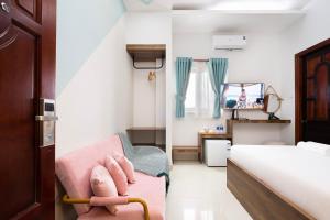 Un dormitorio con una silla rosa y una cama en Vivianne Boutique Hotel, en Ho Chi Minh