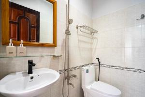 y baño con lavabo, aseo y espejo. en Vivianne Boutique Hotel, en Ho Chi Minh