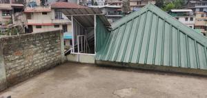 a green building with an open door in a city at Mabie Homestay in Kohīma