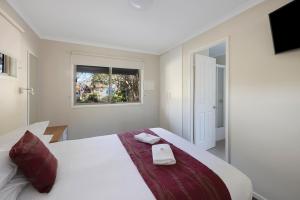 1 dormitorio con 1 cama con 2 toallas en Reflections North Haven - Holiday Park, en North Haven
