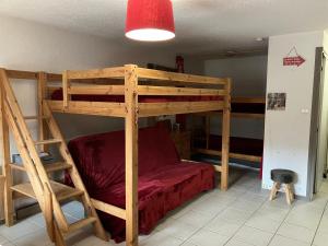 a bedroom with a bunk bed with a red bedspread at Appartement chalet Bellevue-pied de la montagne - Mont Dore in Le Mont-Dore