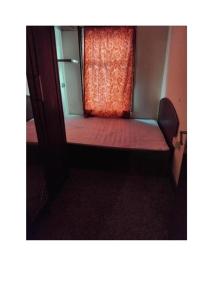 Cama pequeña en habitación con ventana en Furnished Room in a house near train station,bus stop and town center, en Plumstead