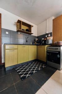 uma cozinha com armários de madeira e um forno com placa de fogão em Studio Nairobi Mvuli em Nairobi