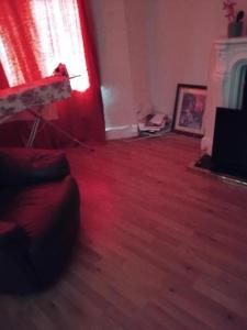 un soggiorno con divano e luce rossa di Furnished Room in a house near train station,bus stop and town center a Plumstead
