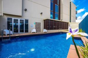 a swimming pool in front of a building at Relax in Style Comfort in Victor Harbor