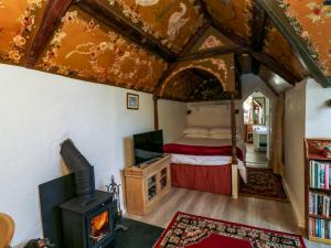 a bedroom with a bed and a wood stove at Toad Hall Cottage in Totnes