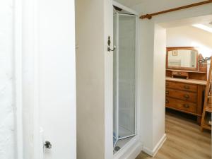 eine Glastür, die in ein Badezimmer mit einer Kommode führt in der Unterkunft Toad Hall Cottage in Totnes + 23 Fotos