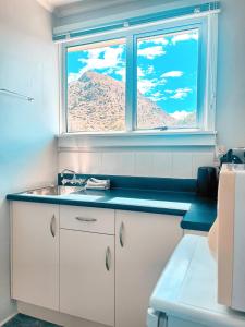 a kitchen with a sink and a window with a mountain at Kurow Motel in Kurow