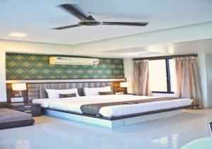 a bedroom with a large bed with a ceiling fan at Hotel Seven Sky in Nashik