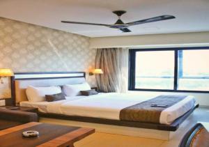 a bedroom with a large bed and a large window at Hotel Seven Sky in Nashik