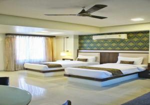 a bedroom with two beds and a ceiling at Hotel Seven Sky in Nashik