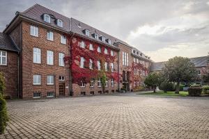 un gran edificio de ladrillo con hojas rojas. en Haus Overbach, en Barmen