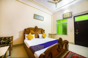 ein Schlafzimmer mit einem Bett und eine Tür mit einem Fenster in der Unterkunft Goroomgo Radhika Kunj Palace Chhatarpur in Chhatarpur