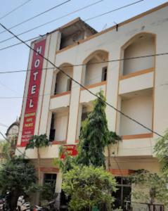 un bâtiment avec un arbre en face dans l'établissement Goroomgo Radhika Kunj Palace Chhatarpur, à Chhatarpur