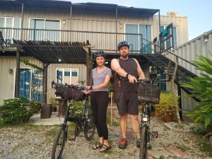 a man and woman standing next to their bikes at LeThuHouse in Melaka