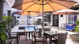 a patio with tables and umbrellas next to a pool at Bavarian Guest House in Angeles