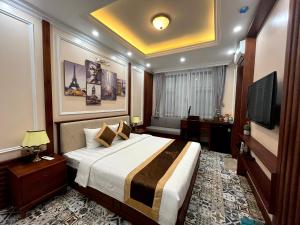 a hotel room with a bed and a television at Paris Of Dragon Bay in Ha Long