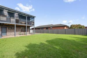 a grassy yard in front of a building at Just Beachy in Indented Head