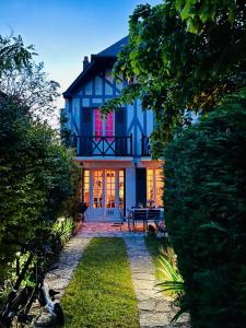 ein blaues Haus mit einem Tisch davor in der Unterkunft Villa normande - Les Crapauds Fous in Deauville