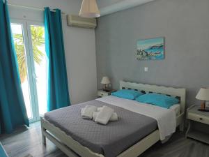1 dormitorio con 1 cama grande con almohadas azules en Athina's blue studios, en Naousa