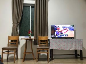 a living room with a tv and two chairs at Mộc Lam Homestay in Xóm Chum Găng