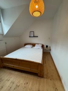 een slaapkamer met een houten bed met een licht bij Petit-Vinave in Malmedy
