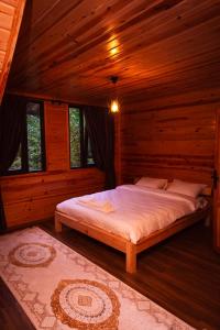 a bedroom with a bed in a wooden cabin at KOZLUCA Bungalov in Trabzon