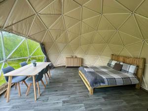 um quarto numa tenda com uma cama e uma mesa em Beavers Retreat Glamping em Tenby