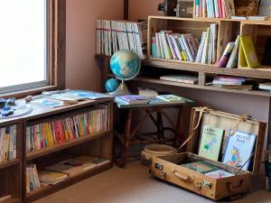 una camera con scrivania e libreria con libri di Mojiko Guesthouse PORTO a Kitakyushu