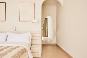 a bedroom with a bed and a mirror on the wall at Casa Mona - Luxury 3 Bedroom Villa in Bingin in Uluwatu