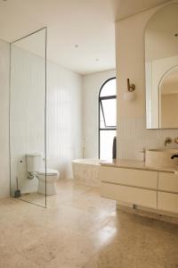 a bathroom with a tub and a toilet and a sink at Casa Mona - Luxury 3 Bedroom Villa in Bingin in Uluwatu