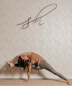uma mulher a fazer uma pose de yoga em frente a uma parede em Agriturismo La Dependance em Sorano