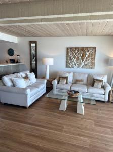 a living room with two couches and a table at Ocean Front Getaway in La Selva Beach in La Selva Beach
