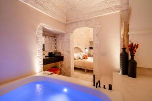 La salle de bains est pourvue d'une grande baignoire bleue. dans l'établissement Naiira Luxury Trullo, à Alberobello