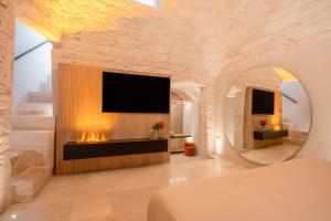 Il comprend un salon avec une cheminée et une télévision. dans l'établissement Naiira Luxury Trullo, à Alberobello