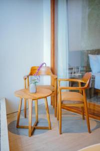 2 chaises en bois, une table et un vase sur une chaise dans l'établissement Agua Hotel, à Kubupenlokan