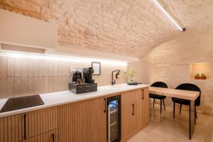 a kitchen with a counter and a table and chairs at Luxury Trullo Jacuzzi & Patio - Naiira in Alberobello