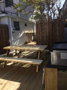 - une table de pique-nique en bois assise sur une terrasse en bois dans l'établissement Avocado Studio, à Nouméa