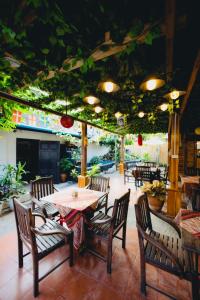 un patio con mesa, sillas y plantas en Chanthavong Hostel en Luang Prabang