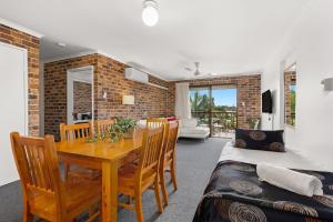 uma sala de jantar com uma mesa e cadeiras e uma cama em Toowong Villas em Brisbane